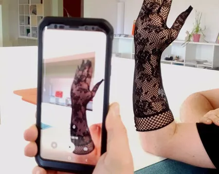 Smartphone filmt eine Hand im Scan-Handschuh, auf dem Display entsteht das 3D-Modell